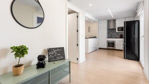 Una cocina moderna con armarios blancos, un refrigerador negro y un microondas.