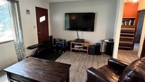 A living room with a TV, a sofa, a coffee table, and a staircase leading to another room. - Puma's executive cat house! (Fernie)