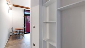 A hallway with a dining area, a door with a handle, and a window with blinds. - Apartment 'La Sartoria' with Dedicated Parking and Air Conditioning (Porlezza)