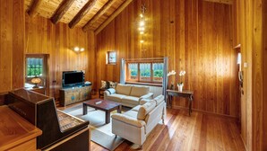 A wooden interior with a sofa, TV, and wooden floors. - Exclusive Chalet 'La Libellula' with Stunning Mountain Views (Scopello)