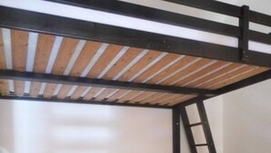 A bunk bed room with a ladder, two bedside tables, and a red rug. - Apartment 'Azur Sancy Skis Aux Pieds' (Le Mont-Dore)
