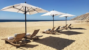 A beach with sun loungers and white umbrellas. - Quivira Ocean view private villa with pool (Cabo San Lucas)