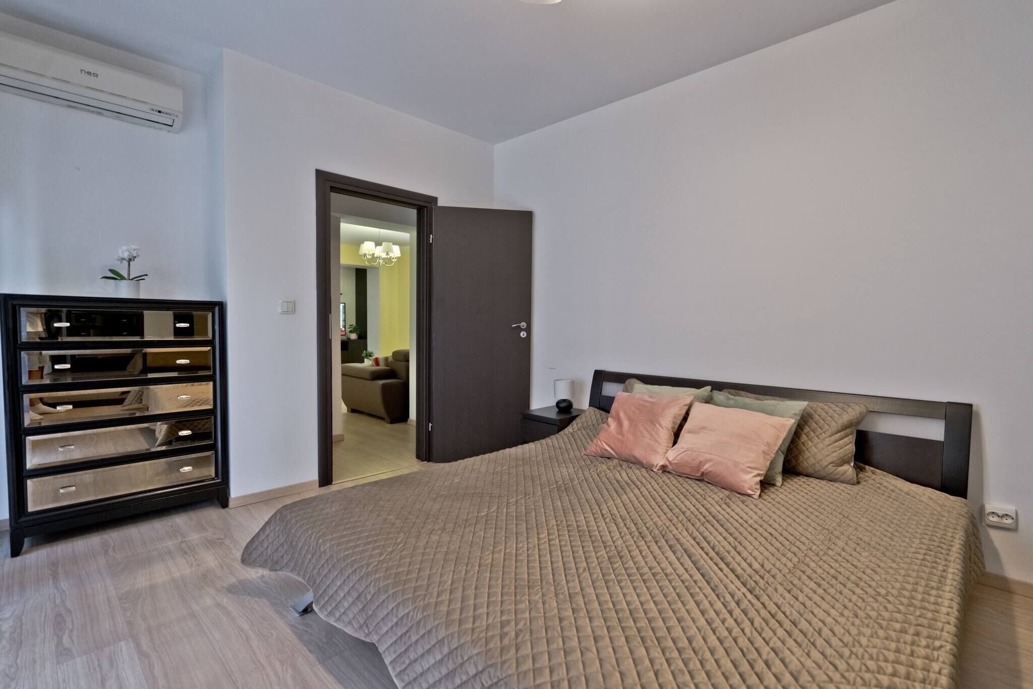 Une chambre à coucher comprenant un lit, une commode et un appareil de climatisation.