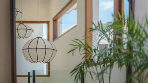 A modern interior with a large mirror, hanging spherical light fixtures, and a potted plant. - Villa Umaju  (Kerobokan)