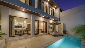 A modern two-story house with a swimming pool, outdoor seating, and a well-lit patio area. - Villa Umaju  (Kerobokan)