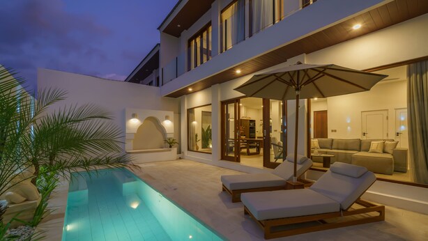 A modern house with a swimming pool, lounge chairs, and a dining area. - Villa Umaju  (Kerobokan)