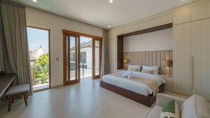 A modern bedroom with a large bed, a desk, and a balcony with a view of the outside. - Villa Umaju  (Kerobokan)