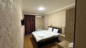 Une chambre d’hôtel avec un lit, une table de chevet et un miroir.