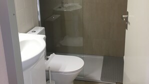 A modern bathroom with a toilet, sink, and shower area.