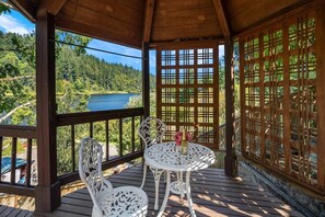 A wooden deck with a table and chairs overlooking a lake and forest. - European White Castle on Lake Desire, Private Dock (Renton)