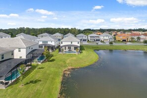 Un quartier résidentiel avec des maisons, une piscine et un étang.