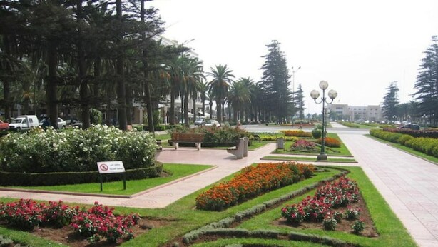 Un jardín ajardinado con un diseño espiral, bancos y un letrero.