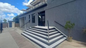 Un edificio moderno con una scala che conduce a un ingresso recintato.