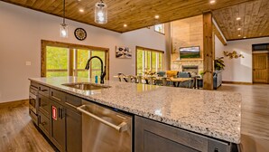 A spacious kitchen with granite countertops, stainless steel appliances, and wooden ceiling beams. - A Piece Of Perfect: Pool, Mtn Views, Home Theater, Game Room, Hot Tub, Wifi (Sevierville)