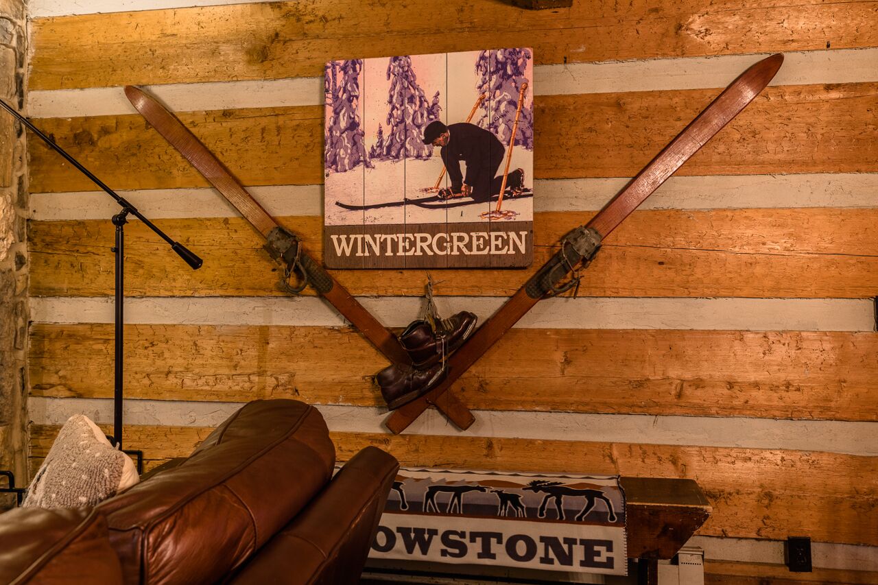Un mur en bois orné de paires de skis et de bâtons de ski croisés, et une enseigne sur laquelle on peut lire « WINTERGREEN ».