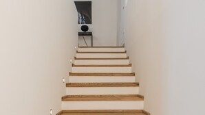 Una escalera con escalones de madera y paredes blancas.
