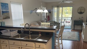 A spacious kitchen with a central island, white cabinetry, and a wooden floor. - “Truly Beautiful”.    Golf Course & Lake View Getaway – Minutes from the Beach! (Pawleys Island)