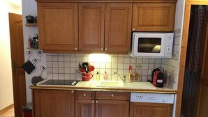 Una cucina con mobili in legno, un forno a microonde, un lavello e una lavastoviglie.