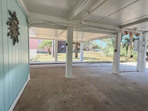 A covered outdoor area with concrete flooring, white columns, and a light blue wall. - St.George Island Bayfront Paradise with Pool,Dock Golf Cart Included (St. Geroge Island)
