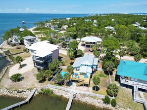 A coastal residential area with houses, a dock, and a beach. - St.George Island Bayfront Paradise with Pool,Dock Golf Cart Included (St. Geroge Island)