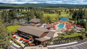 A resort with a pool, outdoor seating, and a mountain backdrop.