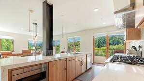Una cocina moderna con una isla grande, armarios de madera y vistas al exterior.