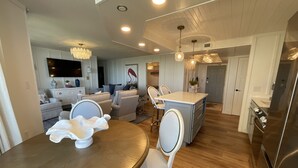 Une cuisine moderne avec un coin repas, un plancher en bois et un îlot central intégré.