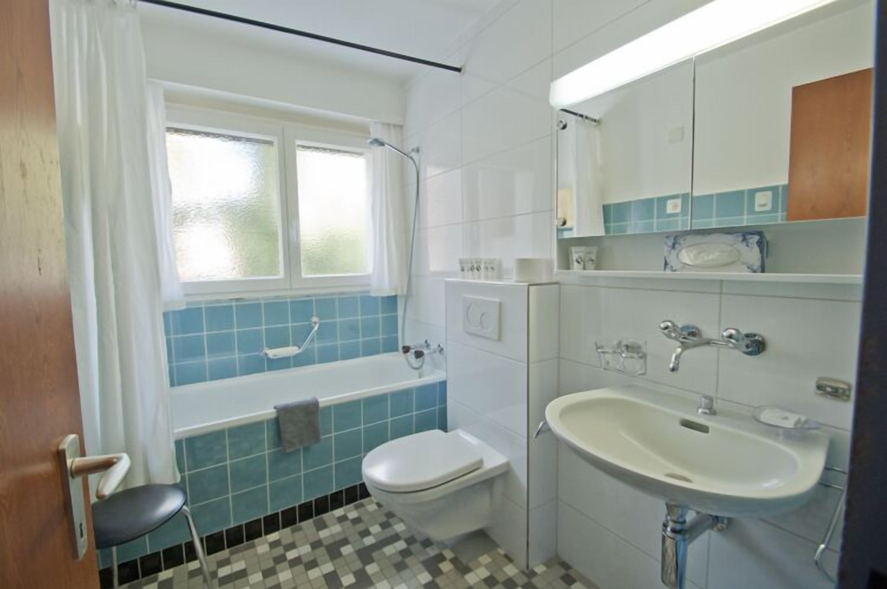 Un baño con bañera, inodoro y lavabo.
