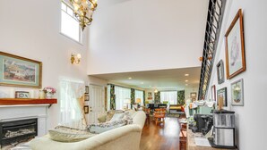 A spacious living room with a fireplace, a dining area, and a kitchen area with a coffee machine. - Spacious & Secluded Shook Home w/ Private Hot Tub! (Lowndes)