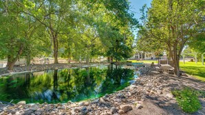 A serene outdoor area with a pond, surrounded by trees and a gravel path. - Cozy Idaho Retreat w/ Grill & Fire Pit! (Caldwell)