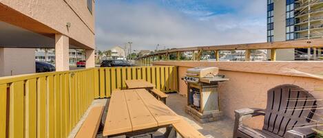 An outdoor patio with picnic tables and a grill.