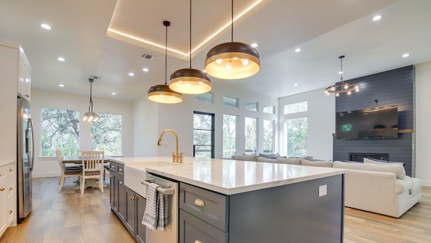 A modern kitchen with a large island, pendant lighting, and a built-in oven. - Modern Kingsland Home w/ River Access & Kayaks! (Kingsland)