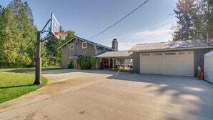 A residential property with a garage, a basketball hoop, and a driveway. - Waterfront Allyn Retreat w/ Guest House & Beach! (Allyn)