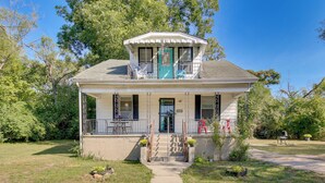 A two-story house with a balcony, a front door, and a small porch area.