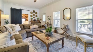 A living room with a sectional sofa, a wooden coffee table, and a ceiling fan. - Fire Pit & Yard: Updated Winter Garden Home! (Winter Garden)
