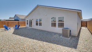 A single-story house with a white exterior, a gravel driveway, and a wooden fence. - Pet-friendly Merced Vacation Rental! (Merced)