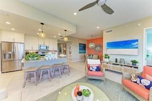 A modern kitchen with stainless steel appliances, a central island with bar stools, and pendant lighting. - Serenity on the Sound, steps to pool/grills (Bradenton)