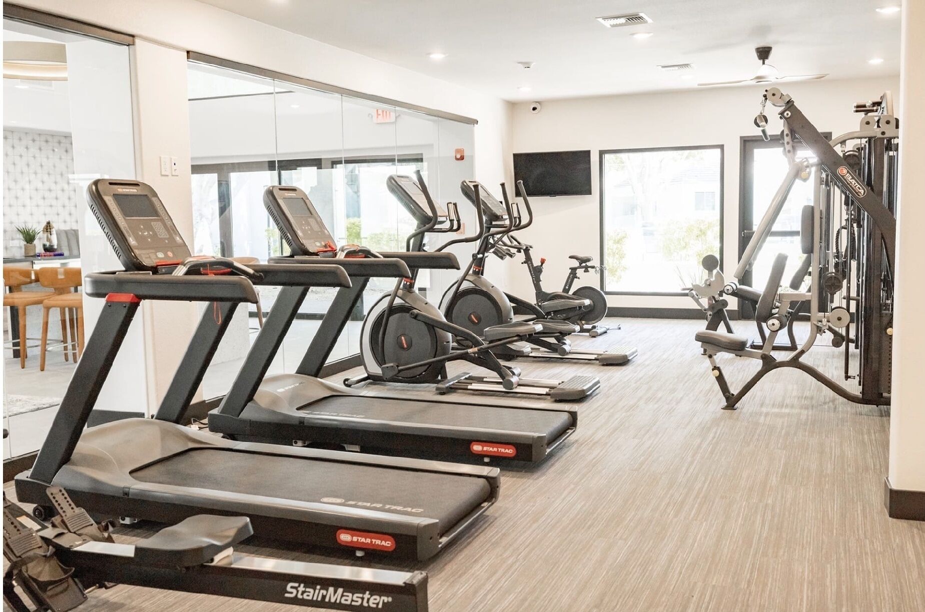 A gym with multiple treadmills, elliptical machines, and weightlifting equipment.