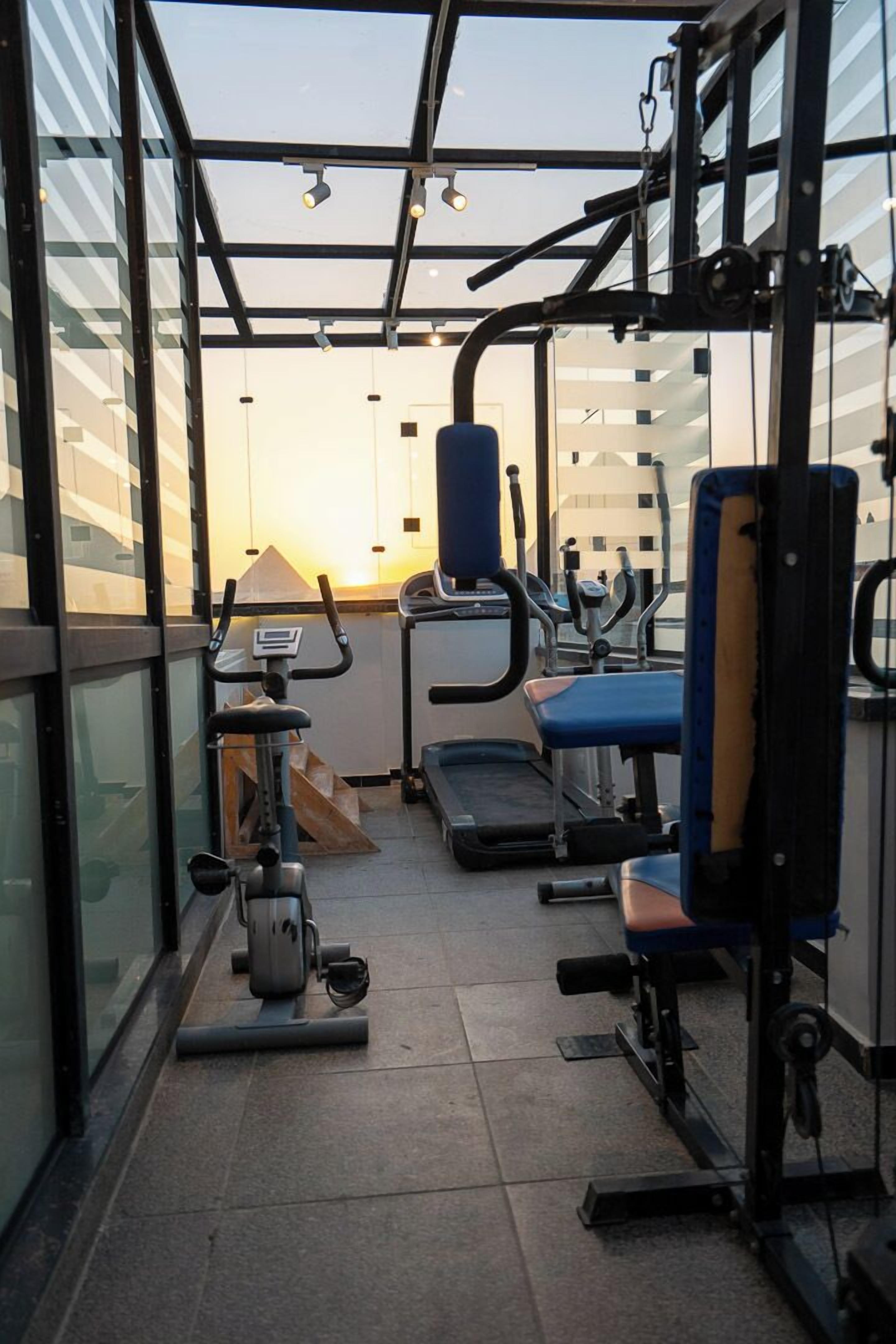 A gym with exercise equipment, a treadmill, and a rowing machine.