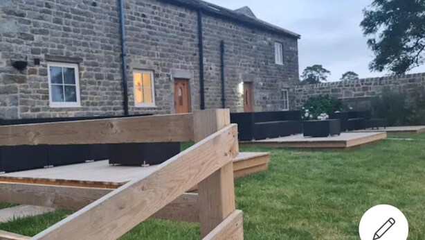 A stone building with a wooden deck and a grassy area in front. - Charming 2 Bed Cottage in Nidderdale Near Harrogat (Harrogate)
