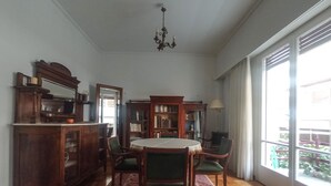 A dining area with a round table, chairs, a patterned rug, and a chandelier. - 3-Generations Athenian home at the foot of the Acropolis hill in Athen"s center (Athina)