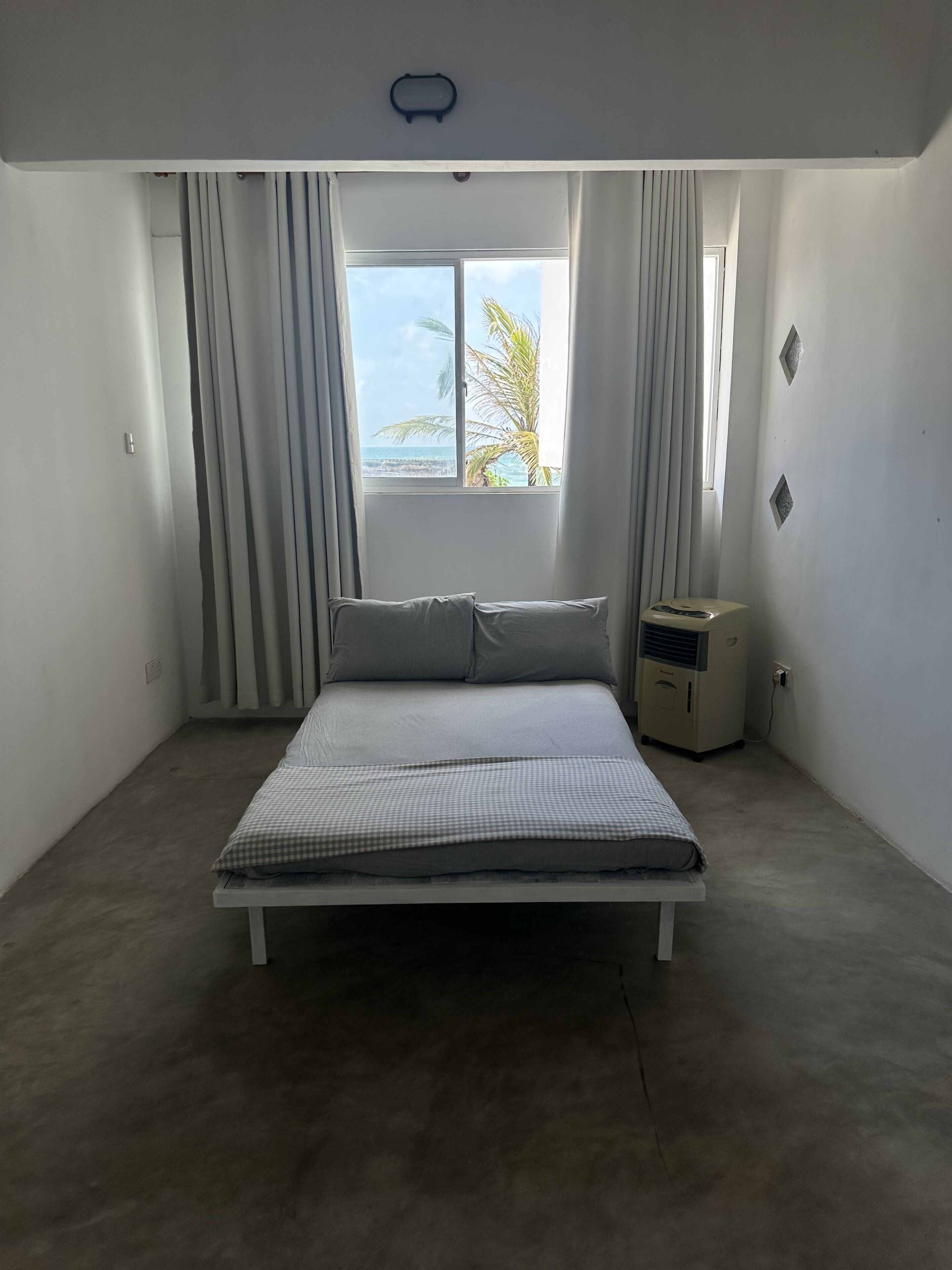 Ein Schlafzimmer mit Bett, einem Fenster mit Meerblick und einer Heizung.