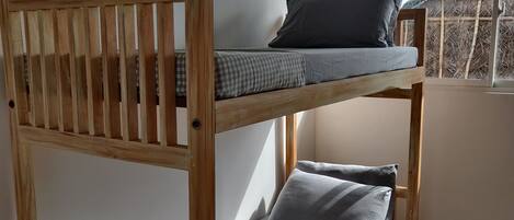 Una cama litera con ropa de cama gris y una colcha a cuadros.