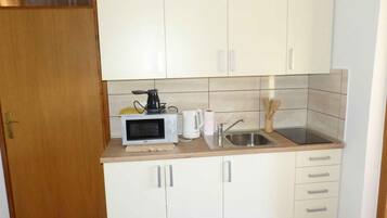 Een koelkast, een magnetron, een kookplaat, een broodrooster