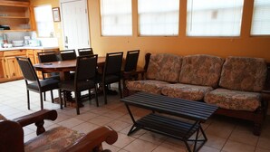 A living room with a sofa, chairs, a coffee table, and a dining table with chairs. - Sunshine cabin with a Shared fishing pier Not waterfront (Rio Hondo)