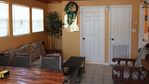 A room with a wooden ceiling, a ceiling fan, a dining table with chairs, a bench, a wooden bench, a door, and a wall-mounted wreath. - Sunshine cabin with a Shared fishing pier Not waterfront (Rio Hondo)