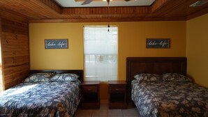 A bedroom with two beds, wooden headboards, and a ceiling fan. - Sunshine cabin with a Shared fishing pier Not waterfront (Rio Hondo)