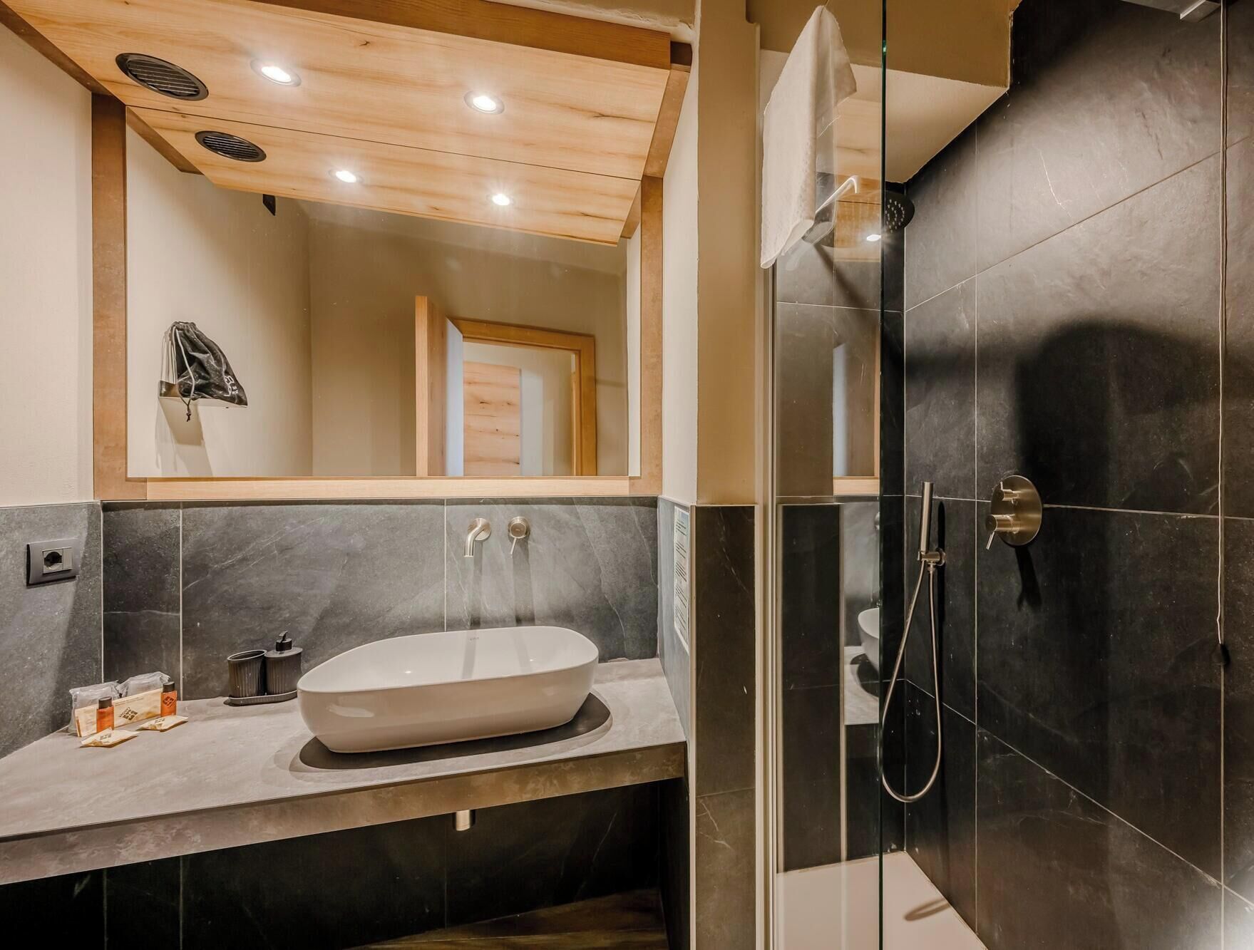 A modern bathroom with a freestanding bathtub, a glass-enclosed shower, and a large mirror above the sink.
