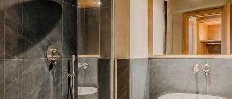 A modern bathroom with a glass-enclosed shower, a white sink, and a wooden ceiling.