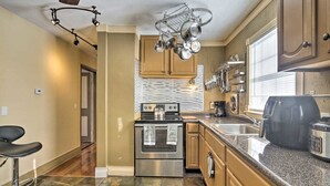 A modern kitchen with stainless steel appliances, a granite countertop, and a hanging pot rack. - New!Quaint & Convenient Hideaway: Great Location (East Hartford)